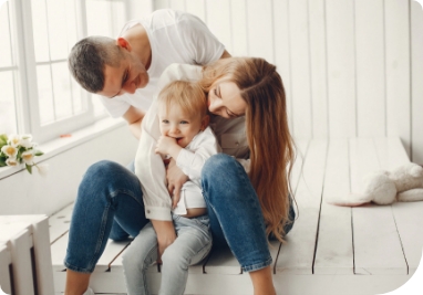 Pai e mãe brincando com o seu bebê na sala de estar